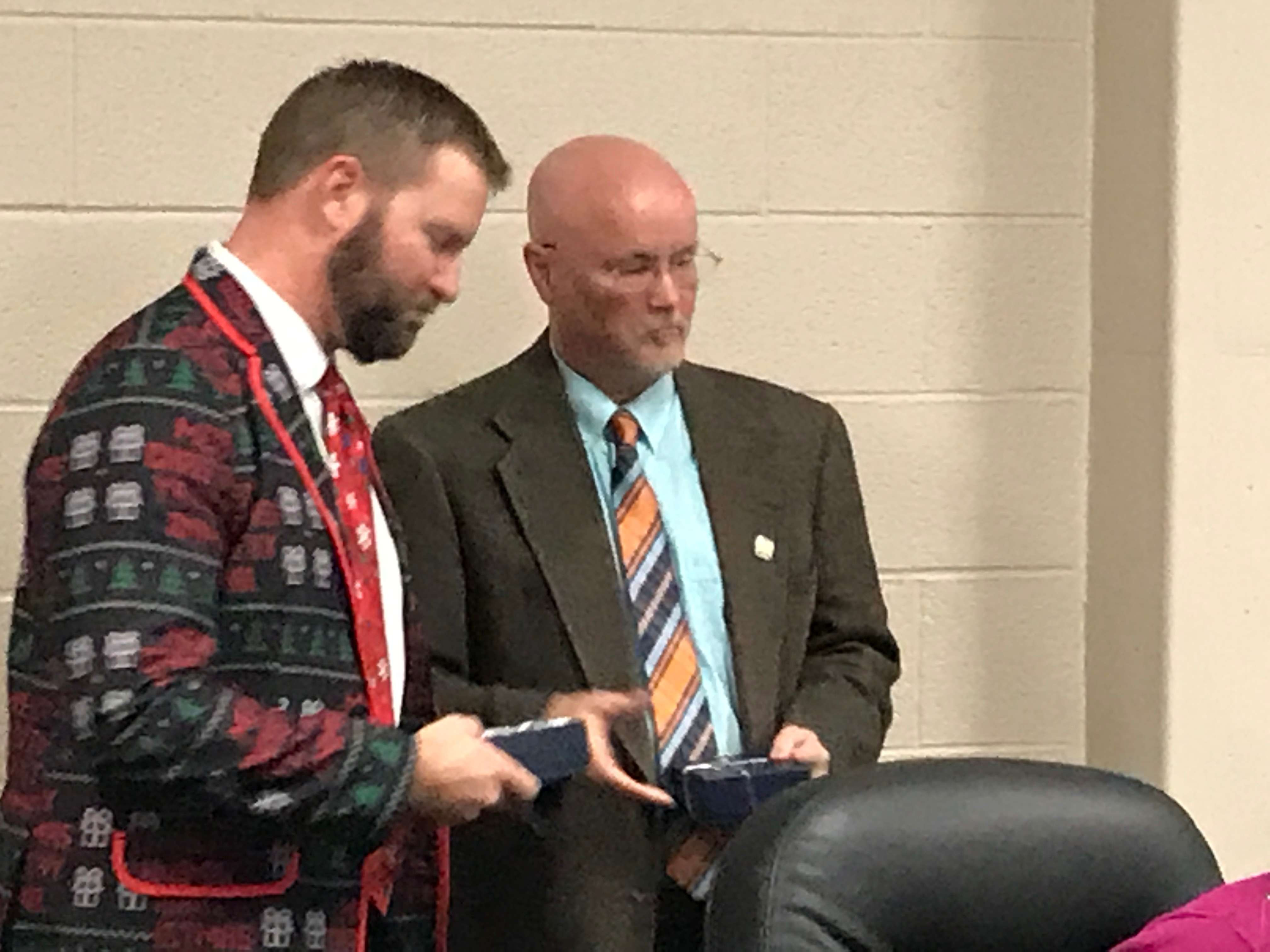 Outgoing board member Luke Oborny is given a gift&nbsp; for his service by USD 489 Board President Mike Walker Monday night at the school board meeting. New school board members will take their seats in January.