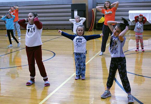 One girl, center, sticks out her tongue as she practices her dance moves. The girls will perform at half time of the EHS basketball came against Hill City on Jan. 17.
