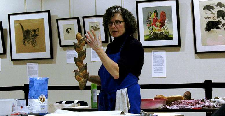 Drabkin displays a bread loaf that has been scored and folded to look like a wheat stalk.