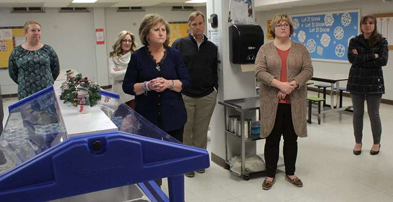 School board members and guests listen to Lincoln Principal Kerri Lacy (not pictured) discuss problems with the school's basement cafeteria. Issues with sewer pipes mean there is a constant odor in the room.