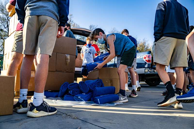 <b>Members of the Sacred Heart Junior/Senior High basketball teams help unload and sort the blankets to be distributed.</b> Photos by Devin Frederking courtesy Saint Francis Ministries