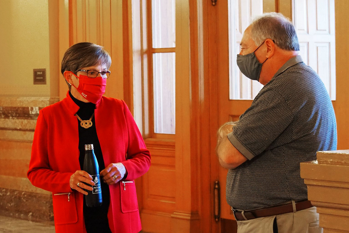 Gov. Laura Kelly, a Topeka Democrat, speaks at the Capitol with Senate Majority Leader Jim Denning, an Overland Park Republican. They disagreed on moving a portion of federal COVID-19 aid into the state's shrinking unemployment trust fund. (Sherman Smith/Kansas Reflector)