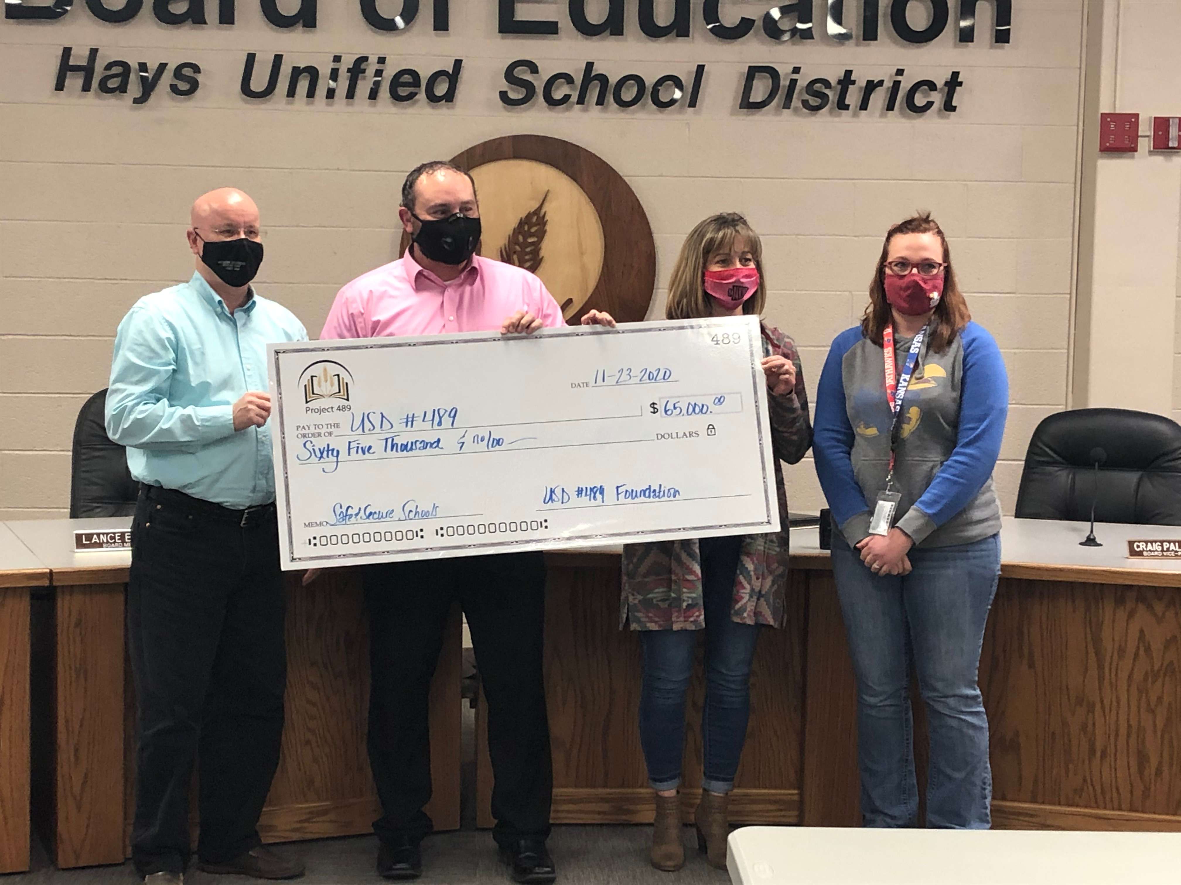 USD 489 school board President Mike Walker accepts a check for $65,000 from the USD 489&nbsp;Foundation for Educational Excellence from the foundation President Curtis Brown, Treasurer Renae Booth and board member&nbsp;Brooke Callaway.