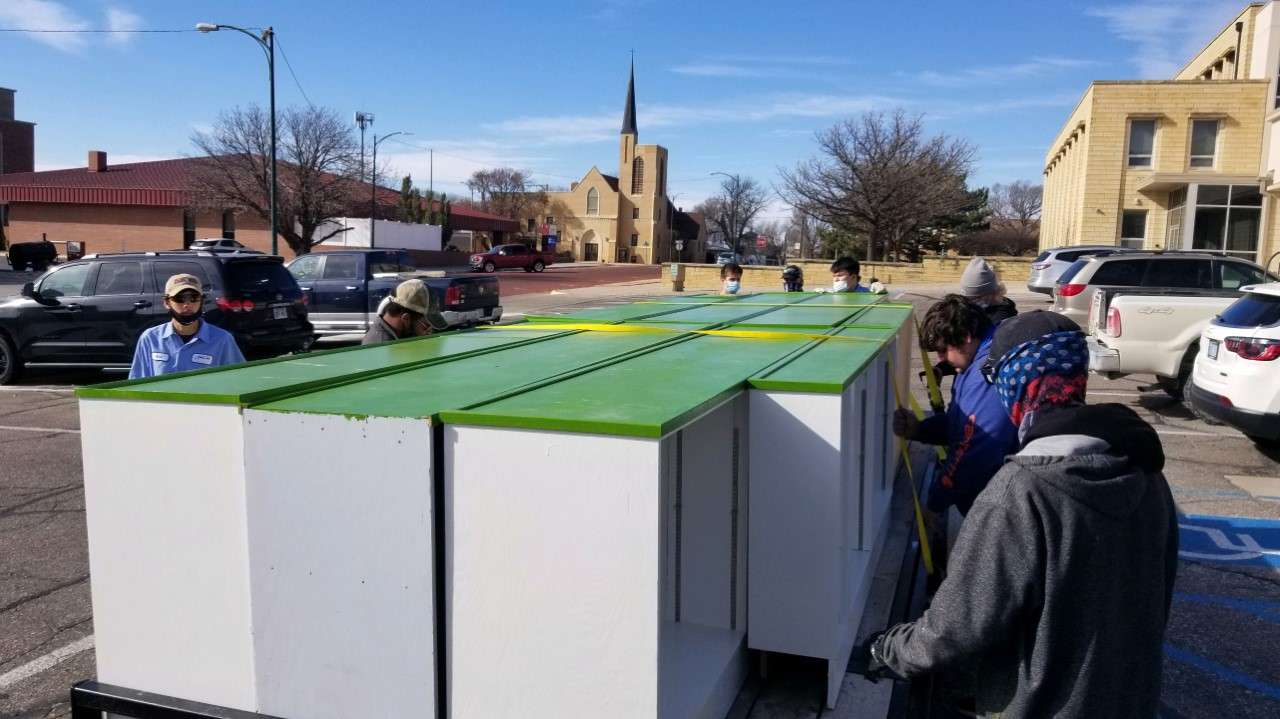 Students deliver the refurbished book cases to the Hays Public Library.&nbsp;