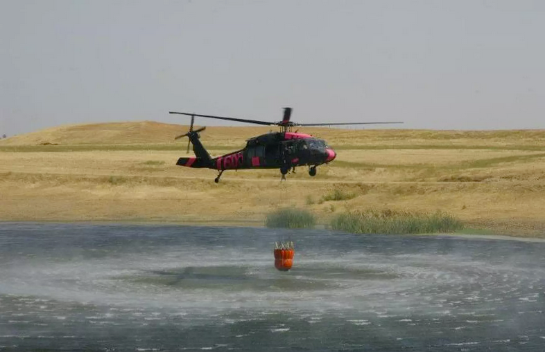 Kansas National Guard troops use a helicopter bucket to fight wildfires in November. This year state National Guards have faced unprecedented duties as they have dealt with natural disasters, overseas deployments and the pandemic. Kansas National Guard