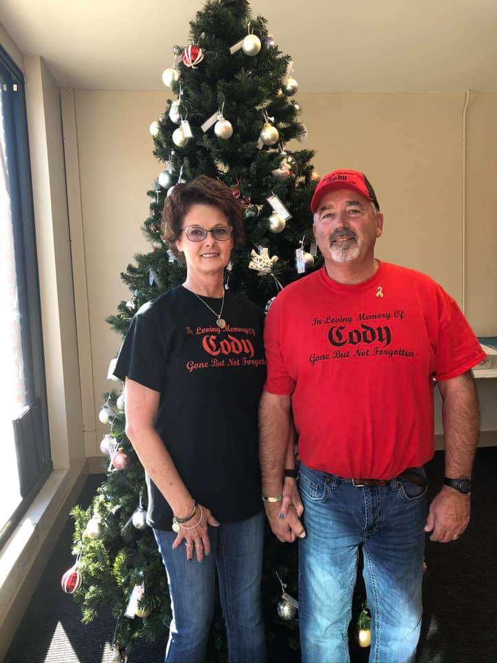 Carolyn and Neal Younger stand next to the Healing Hearts memory tree where families can honor children who have died.