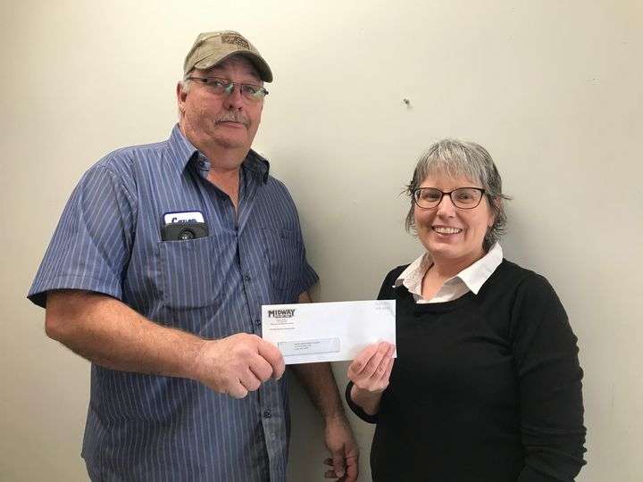 Caven Portenier, Midway Co-op Luray station manager, presents a donation check to and Dawn Rose, Luray UMC Food Pantry.