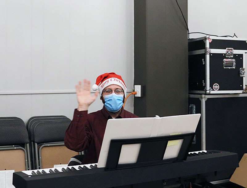 The Hays Community Theatre accompanist gives a little wave during practice Dec. 8.