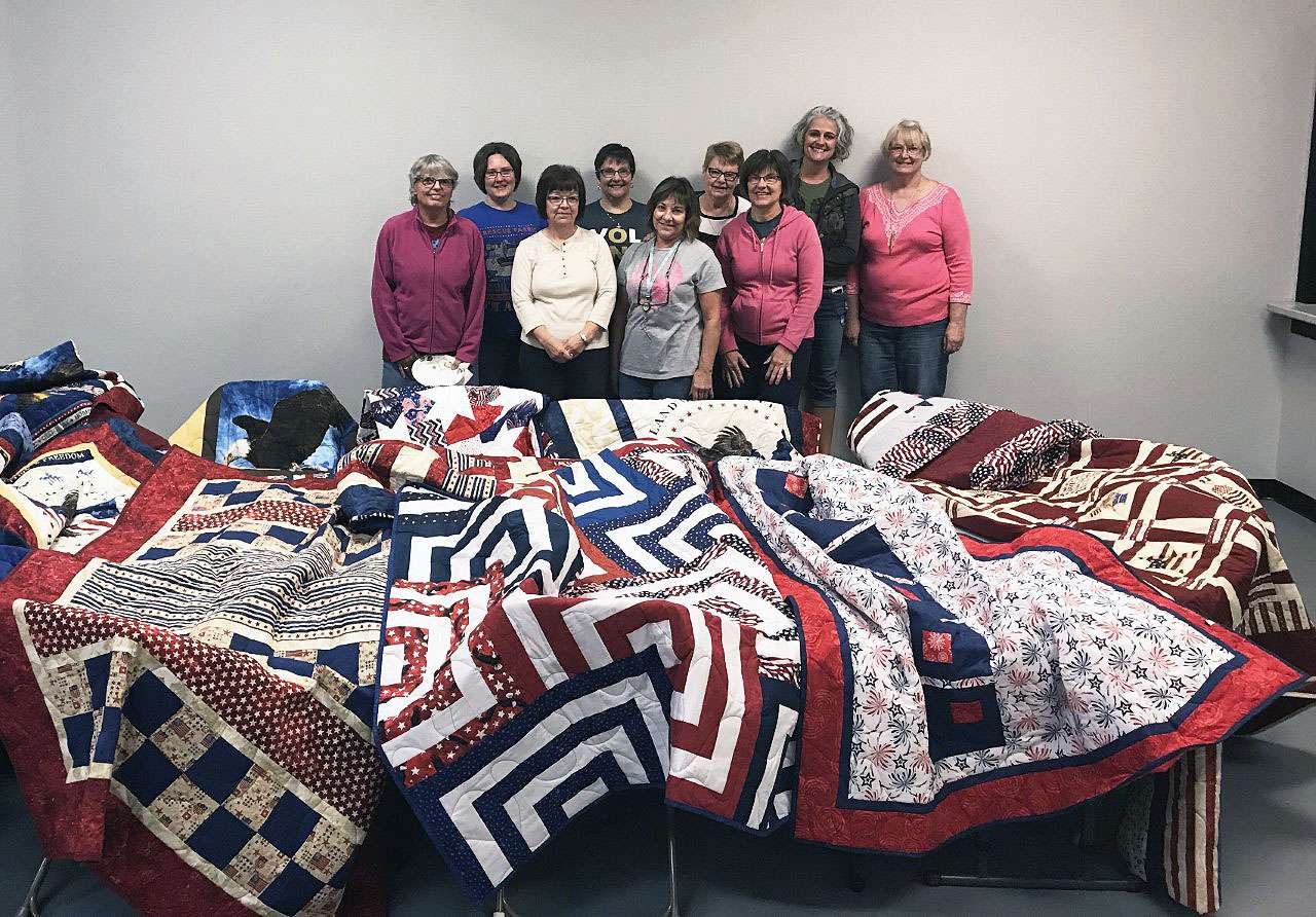 Members of the quilt ministry display patriotic quilts that were distributed to veterans who were being treated for PTSD.