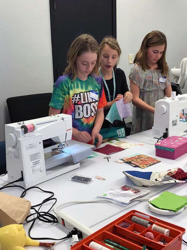 Girls practice their sewing skills in a quilt ministry class. The classes were suspended in part because of COVID-19, but the group would like to offer them again when the pandemic restricts ease.