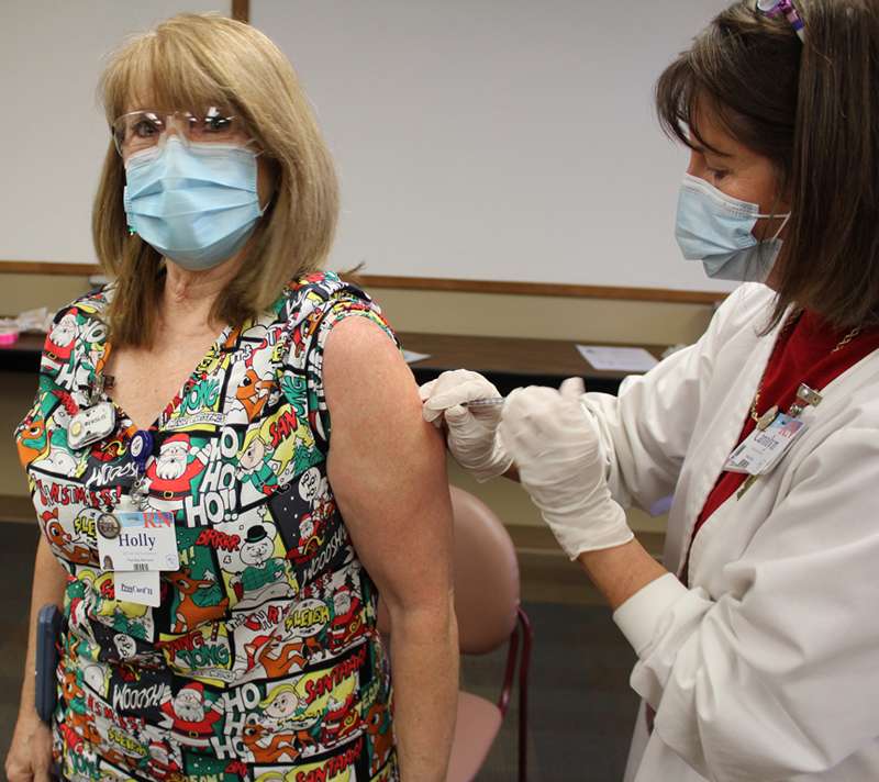 <i><b>Holly Pomeroy (left), Registered Nurse and OB Unit Coordinator, was the first Memorial Health System employee to receive the COVID-19 vaccine Thursday morning. Registered Nurse and Quality and Risk Manager, Carolyn Mikesell (right), is shown administering the shot.</b> Photo courtesy MHS</i>