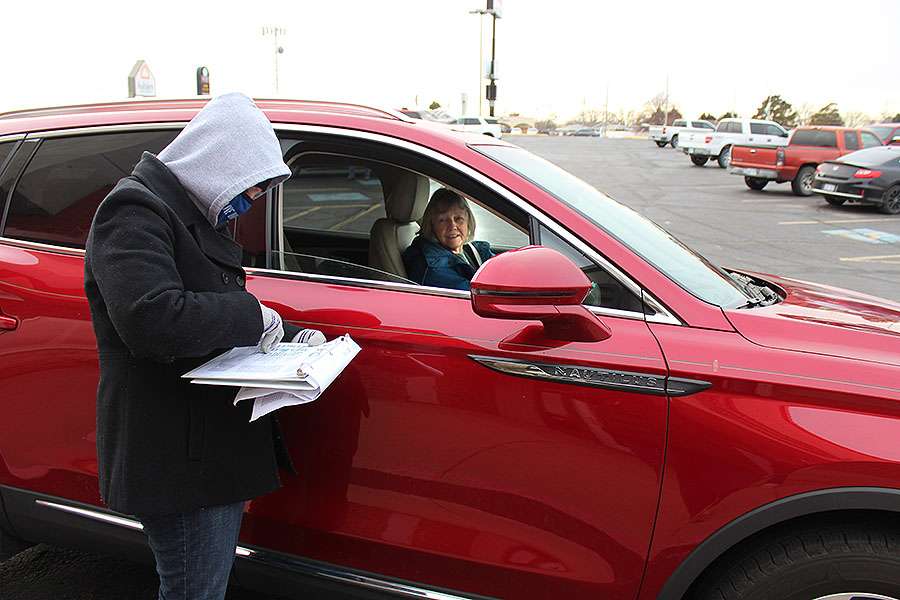 Erica Berges, United Way of Ellis County director, helps a woman with her Christmas dinner order on Wednesday at Thirsty's.