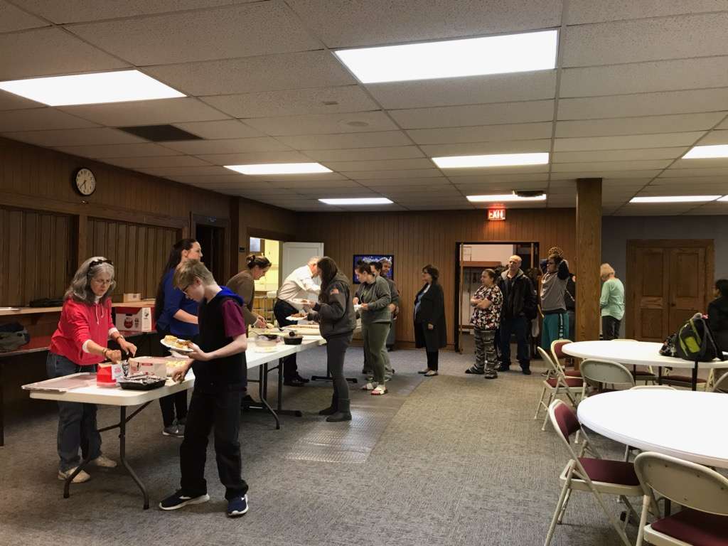 Sunflower Diversified Services staff members serve dinner to Core Community participants at a recent meeting. Sunflower emphasizes community involvement.