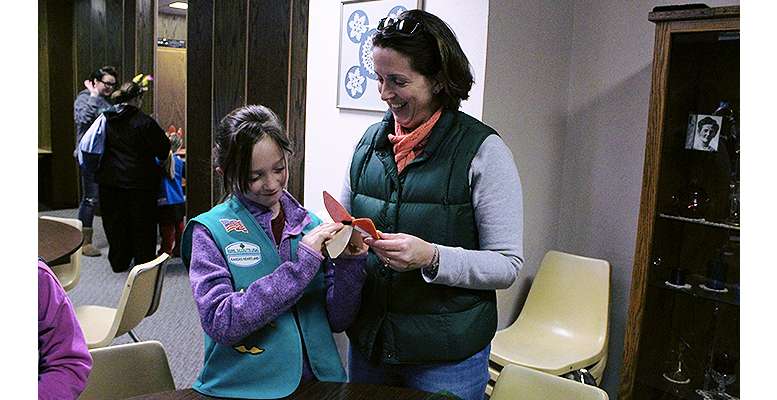Mia Lee , 10, and Marnie Lee, Mia's mother, make a fox ear headband at the Girl Scout Cookie Kickoff Sunday in Hays. This year's cookie mascot is Fiona Fox.