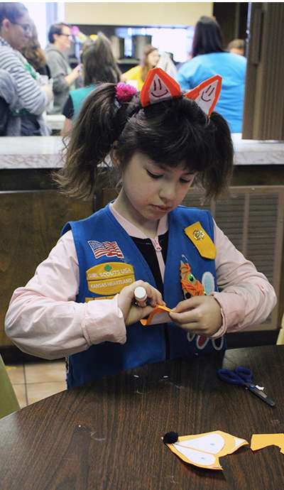 Karli Bradley, 7, Daisy Girl Scout, of Hays, makes a fox Valentine for a veteran on Sunday.