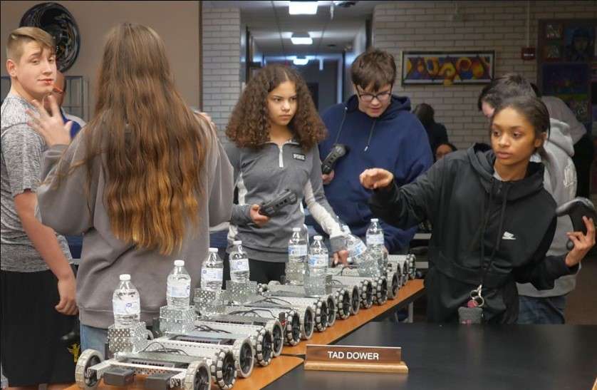 PHOTO COURTESY OF USD 308: Students from HMS-8 show off their Vex robots as they deliver water to board members during their Monday agenda session. The class is taught by Mike Nugent.&nbsp;