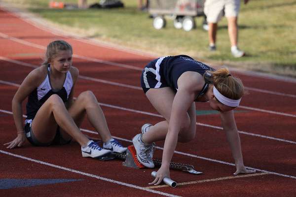 MK Dwyer, TMP senior, in the blocks, with Emily Shippers sitting, is disappointed she will miss her senior year of track at TMP.