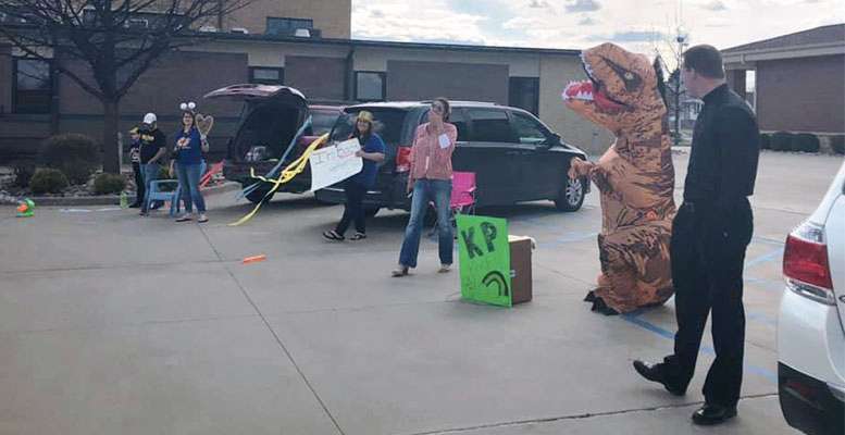 Holy Family Elementary School teachers wave to students and their families on Sunday as they drive through the Holy Family parking lot. Photo courtesy of Holy Family Elementary School.