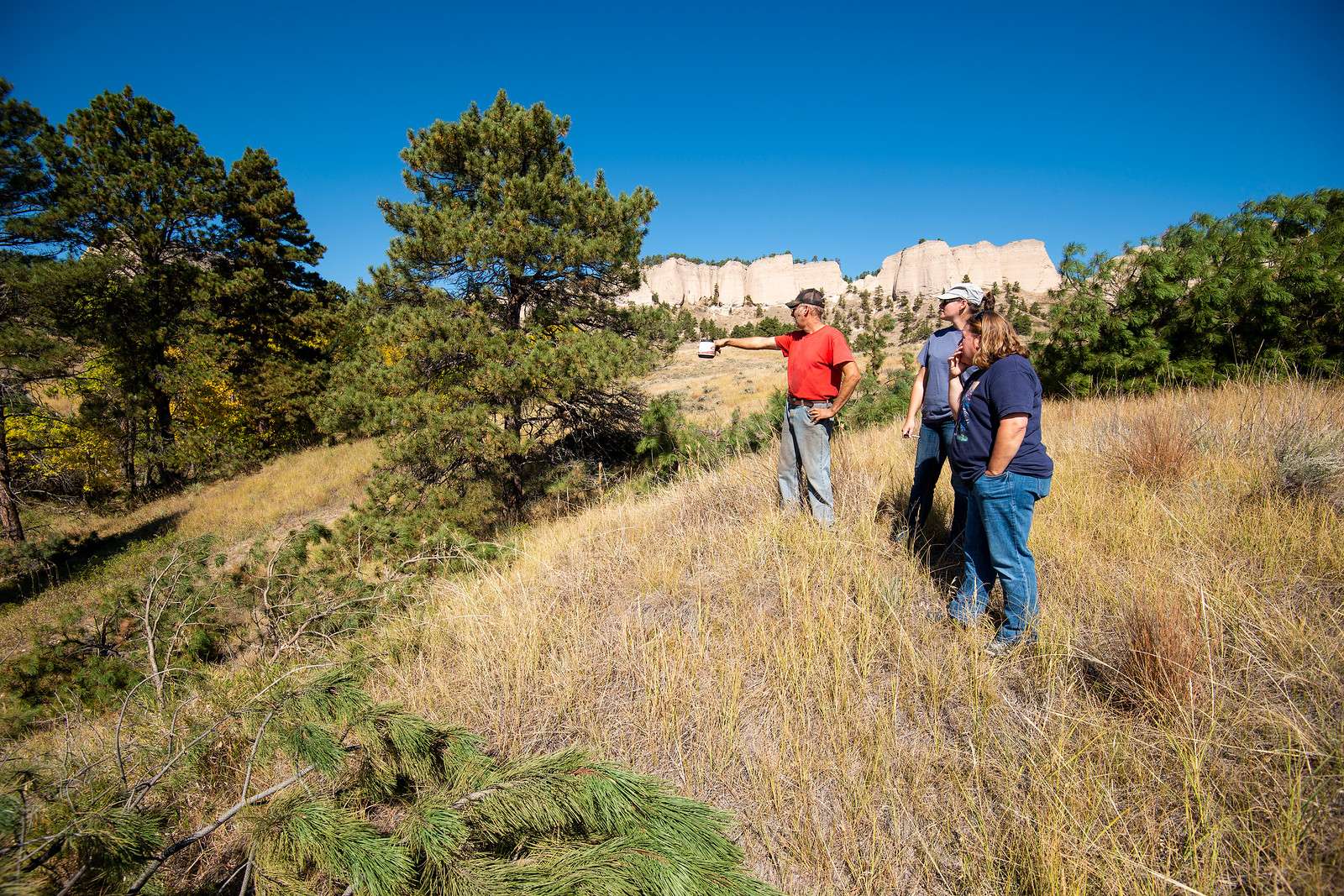 Game and Parks employees Shelley Steffl, near, and Erin Devine survey a thinning area at Fort Robinson State Park with contractor Forrest Futere in 2017. (Nebraskaland/Justin Haag)
