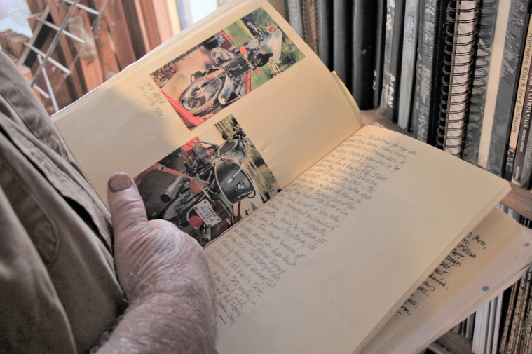 Letner, an artist and sculptor, flips through a journal with photos of his now-destroyed motorbike. He has chronicled his daily thoughts and experiences since the accident.