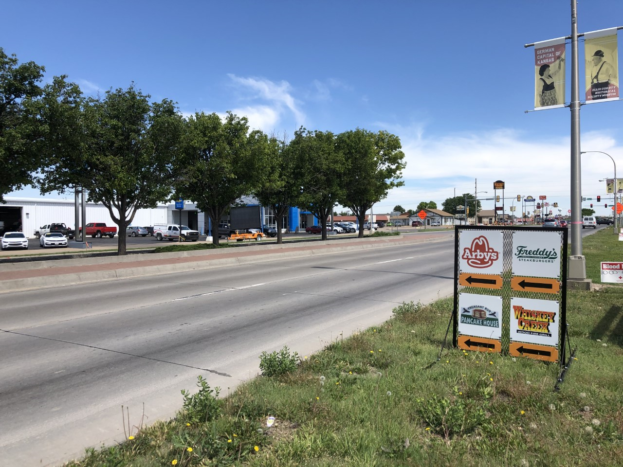 A directional sign for northbound drivers indicates where to turn to access four restaurants on the west side of north Vine.