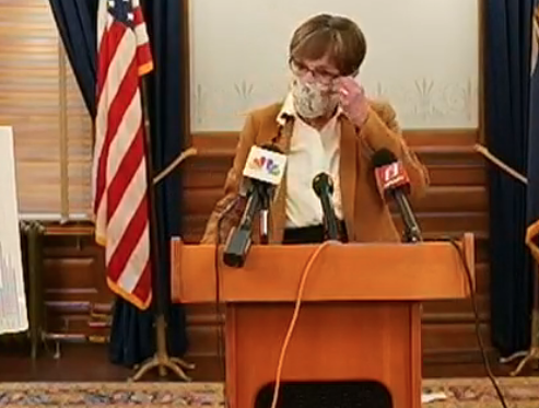 Gov. Laura Kelly arrived at Monday's press briefing wearing a mask