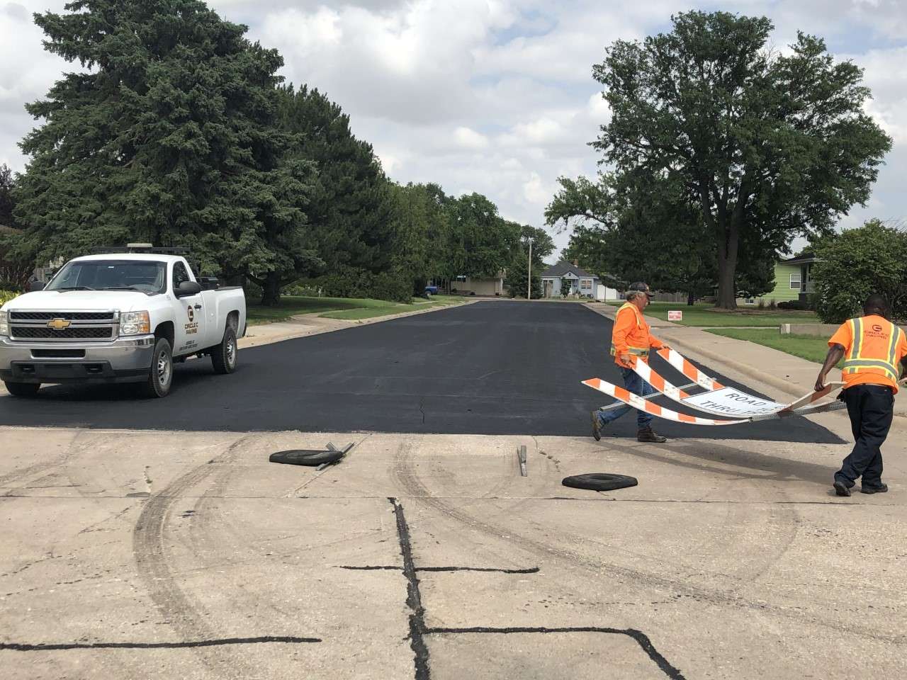 A crew from Circle K Paving, Goddard, reopens the street&nbsp; Wednesday afternoon at 15th and Holmes. The seal coat project has been delayed due to equipment problems and will resume July 6. (Photo by Hays Post)
