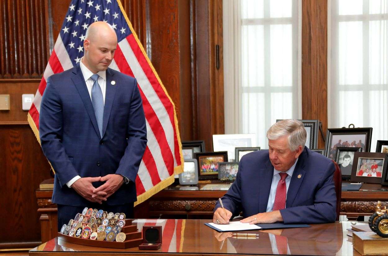 Sen. Tony Luetkemeyer looks on as Gov. Mike Parson signs SB 676 into law/Photo courtesy of Sen. Luetkemeyer's office