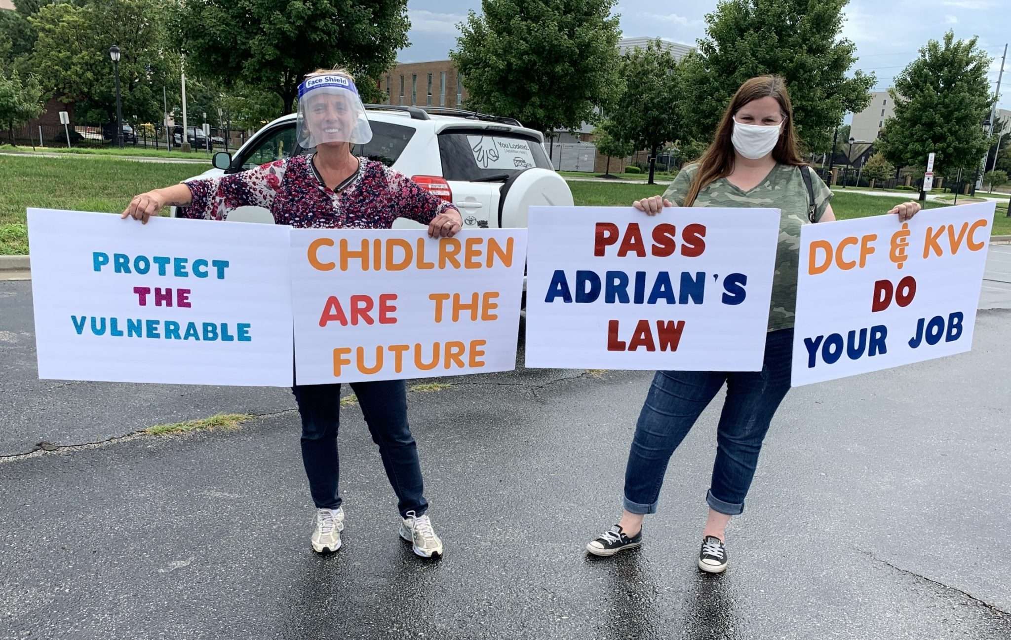 Laura Singer (left) and Shannon Shelton (right) brought extra signs to push for Adrian’s law and call for change in the DCF system, July 29, 2020 (Noah Taborda/Kansas Reflector)