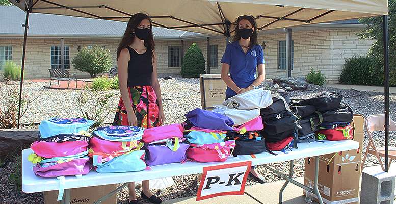 Volunteers man a station at the Backpack for Kids distribution Thursday at the First Presbyterian Church in Hays.