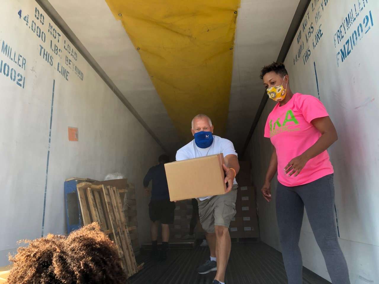 ( L-R ) Randall Zimmerman and Rina Neal were among the many volunteers helping unload the food out of a truck.