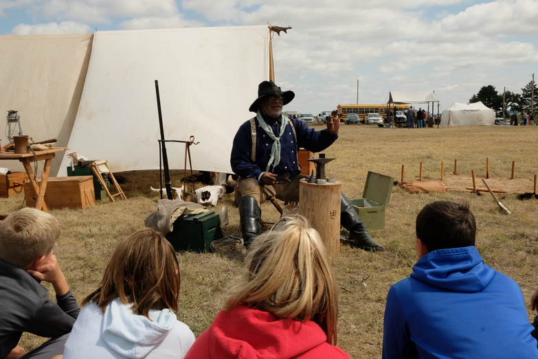 Henry Crawford demonstrates to Wallace County schoolkids during a field trip in September how to load the antique cartridges once used for buffalo hunting on the Kansas plains.&nbsp;Esther Honig / For the Kansas News Service