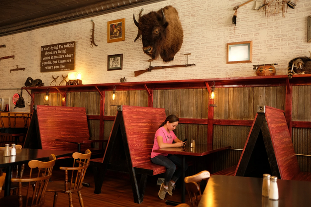 At the Townsend Tavern in Wallace, Kansas, Erin Wright’s niece plays on a phone below the family’s buffalo head.