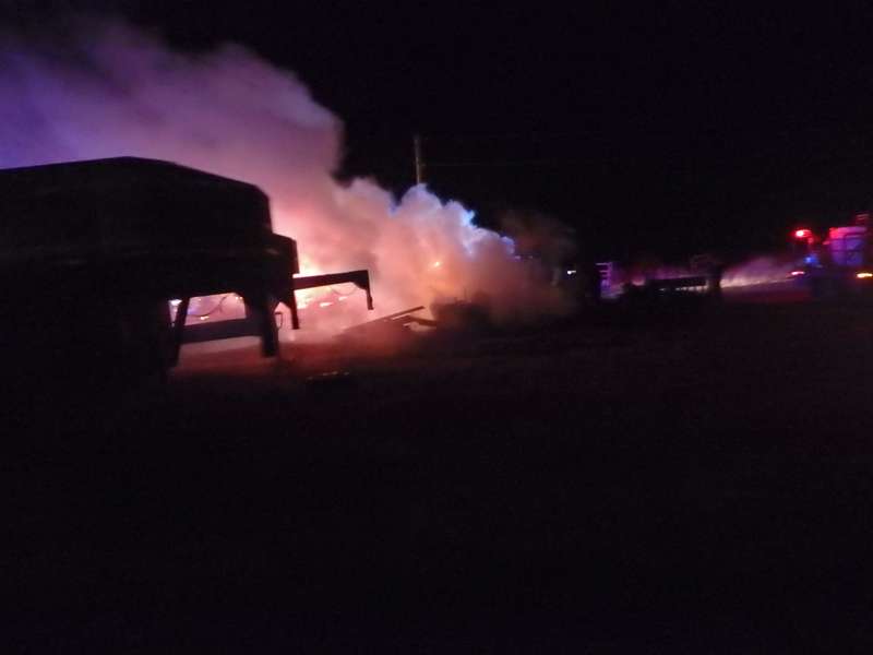 <b>Fire from the burning sheds lights up the smoke.</b>