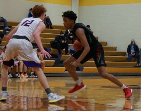 Mid-Buchanan sophomore Joe Clark, who was named the North Platte tournament MVP, attempts to drive the lane against Mound City's Gage Salsbury. Photo by Whitnee Ice.