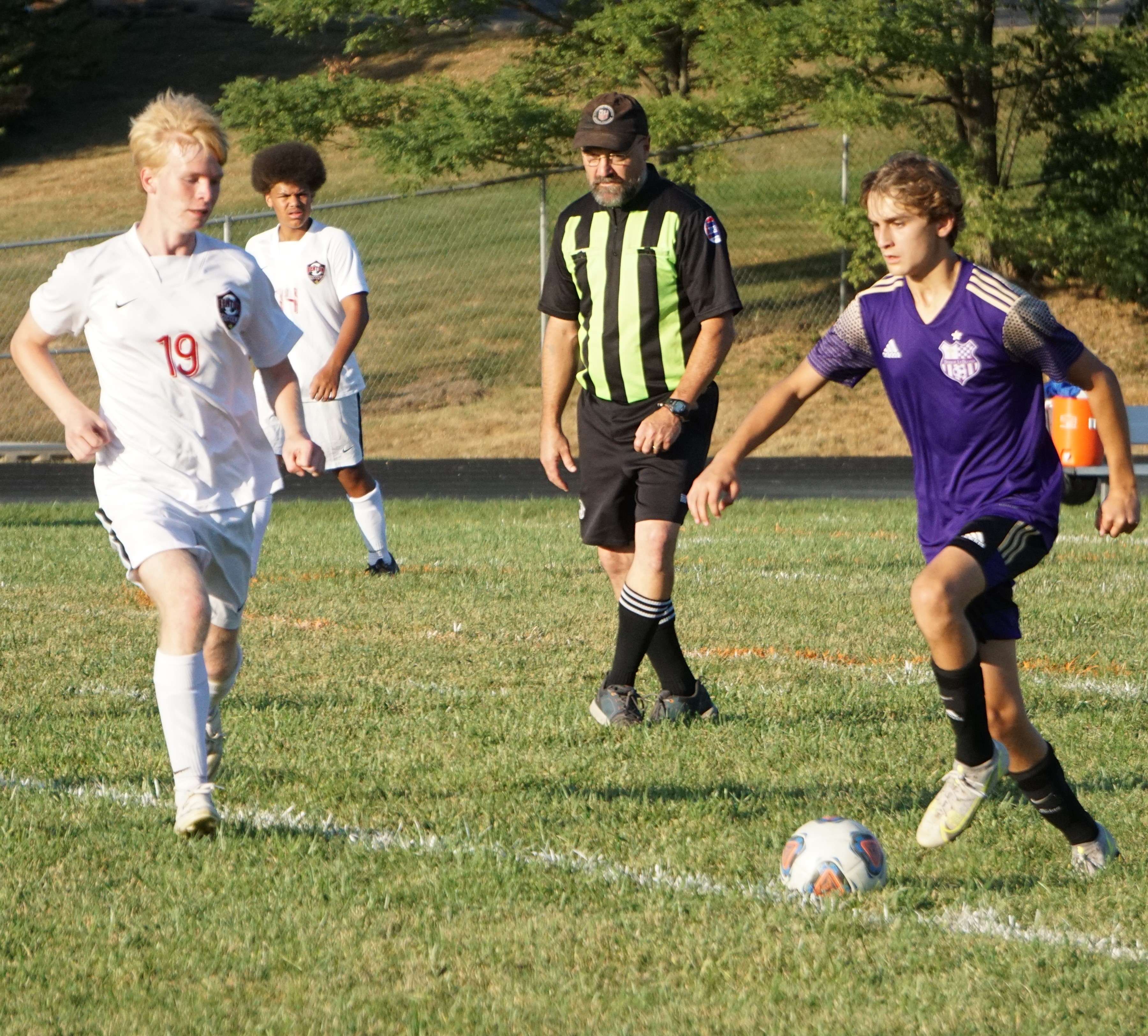 Davis Jungbluth (right) dribbles past Benton's Sage Miller (19).