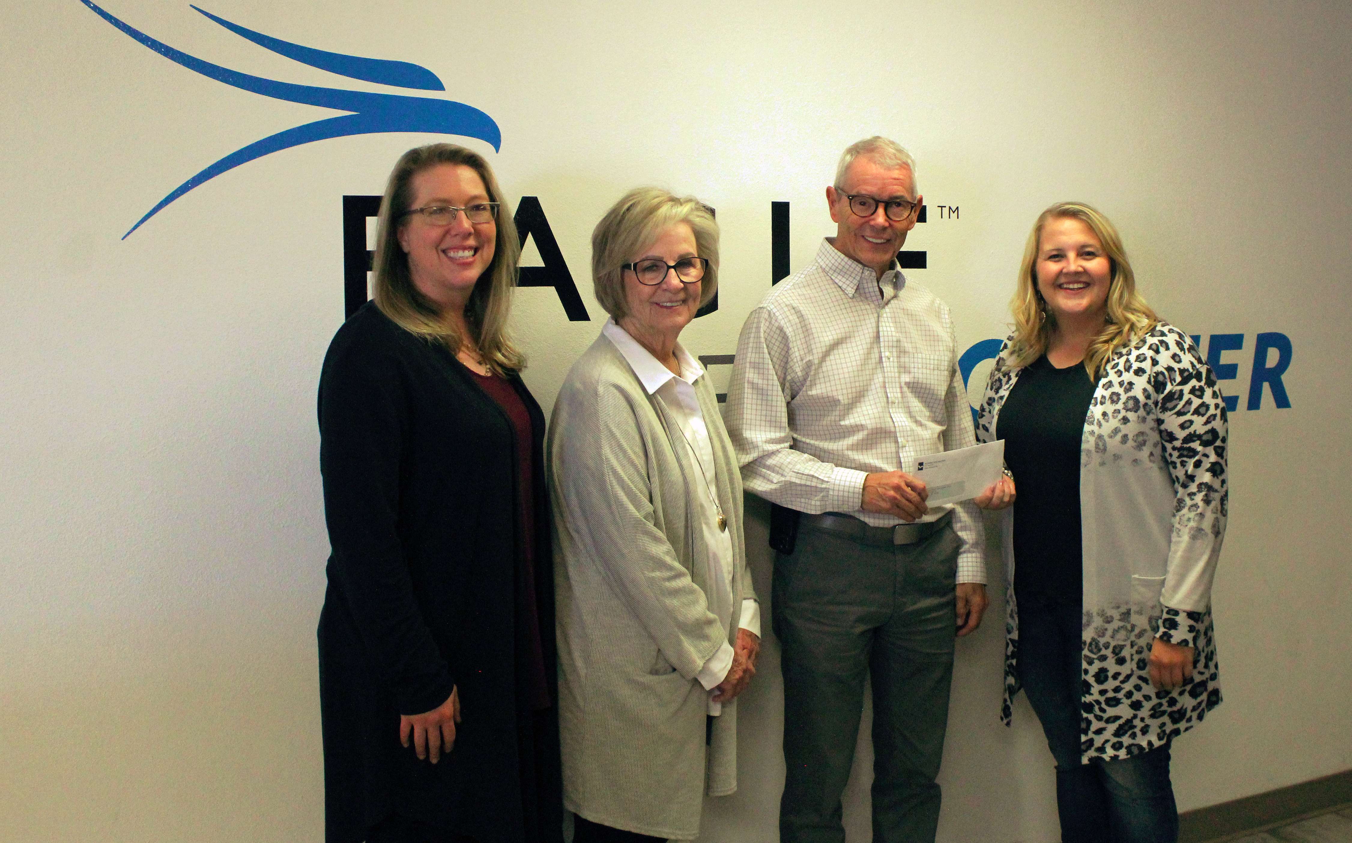 Katie Dorzweiler, representing the Schmidt Foundation, presents a check for $50,000 to Imagine Ellis County, represented (from left) by Sarah Wasinger, Sandy Jacobs and Doug Williams.<br>