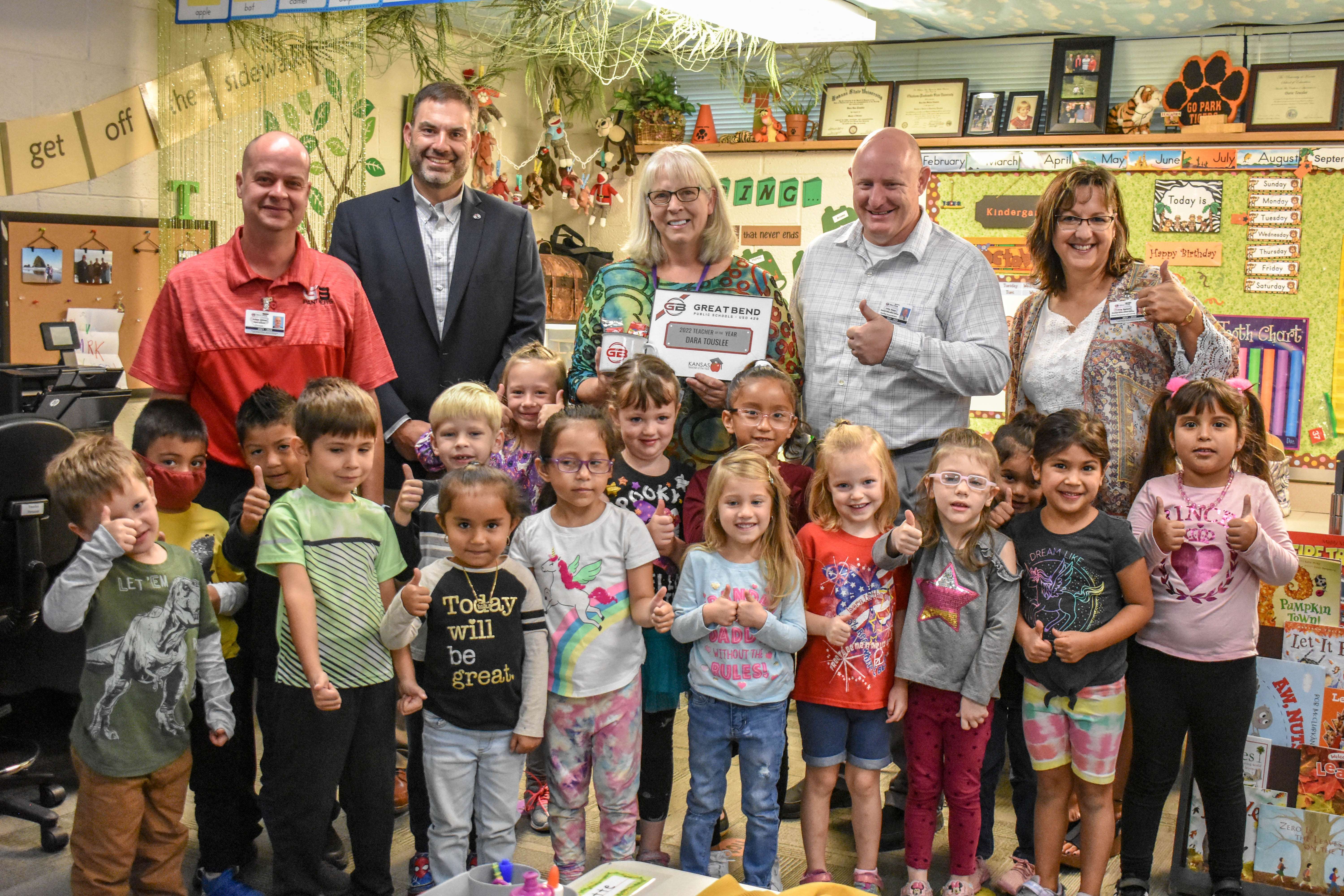 Surrounded by an audience of kindergarten students, Dara Touslee, teacher at Park Elementary School, was named the 2022 USD 428 Elementary Teacher of the Year. Pictured left to right: Adam Cline, principal of Park Elementary; Khris Thexton, superintendent; Dara Touslee; John Popp, assistant superintendent and Tricia Reiser, director of teaching and learning.