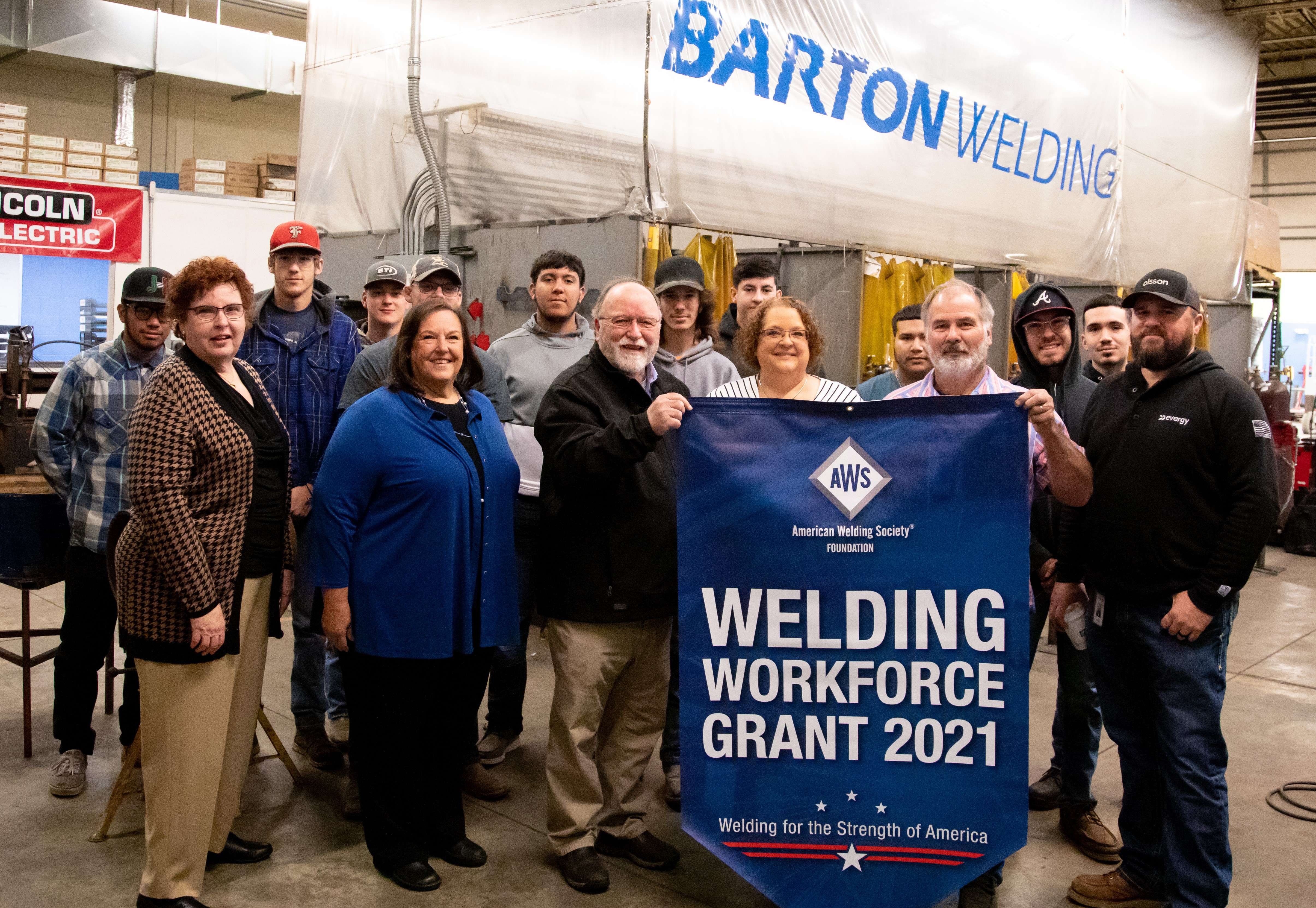 Shown are (front row, from left) Vice President of Instruction Elaine Simmons, Dean of Workforce Training and Community Education Kathy Kottas, American Welding Society (AWS) District 16 Director Karl Fogleman, Executive Director of Workforce Training and Economic Development Mary Foley, Welding Instructor Wade Morris, and Welding/Maintenance Coordinator for Evergy of Kansas City Jeffrey Jones. The representatives posed with students currently enrolled in Barton's welding program who were attending class Thursday morning.&nbsp;