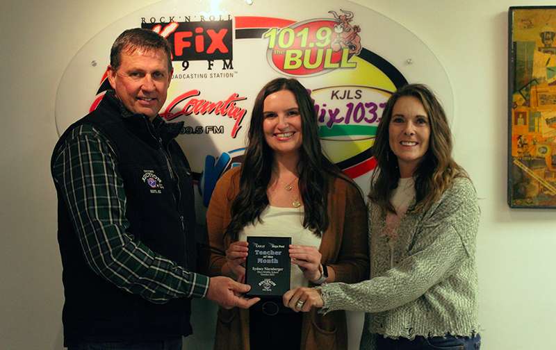 Sponsors Mark and Lynette Ottley of Nations Auction and Elite Realty present Sydney Niernberger, sixth-grader teacher at Hays Middle School, with the October Hays Post Teacher of the Month award.<br>