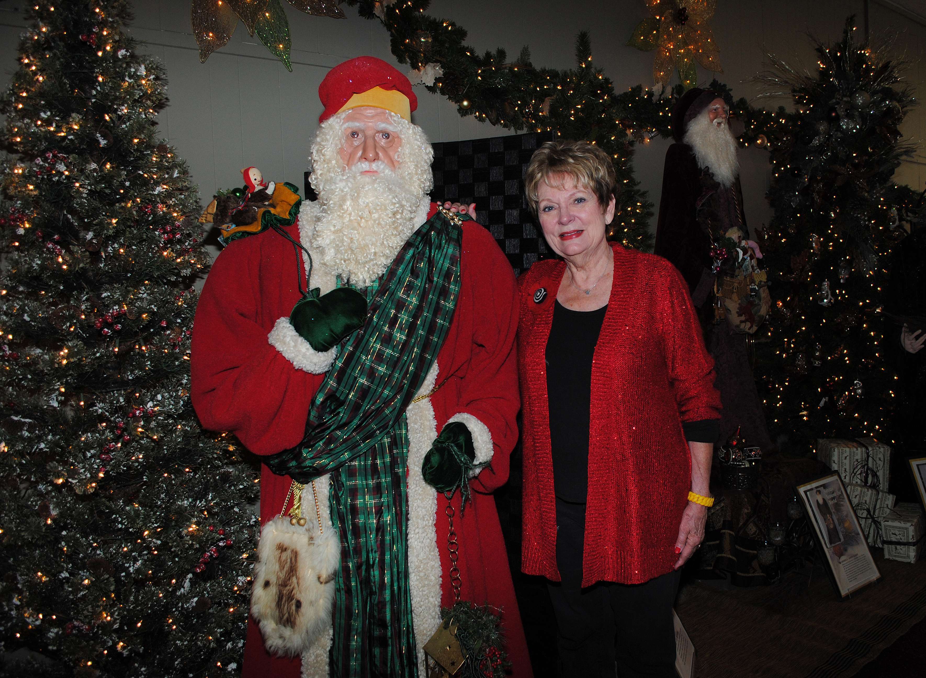 Santa sculptor Loretta Miller stands with one of her 24 Santa creations.