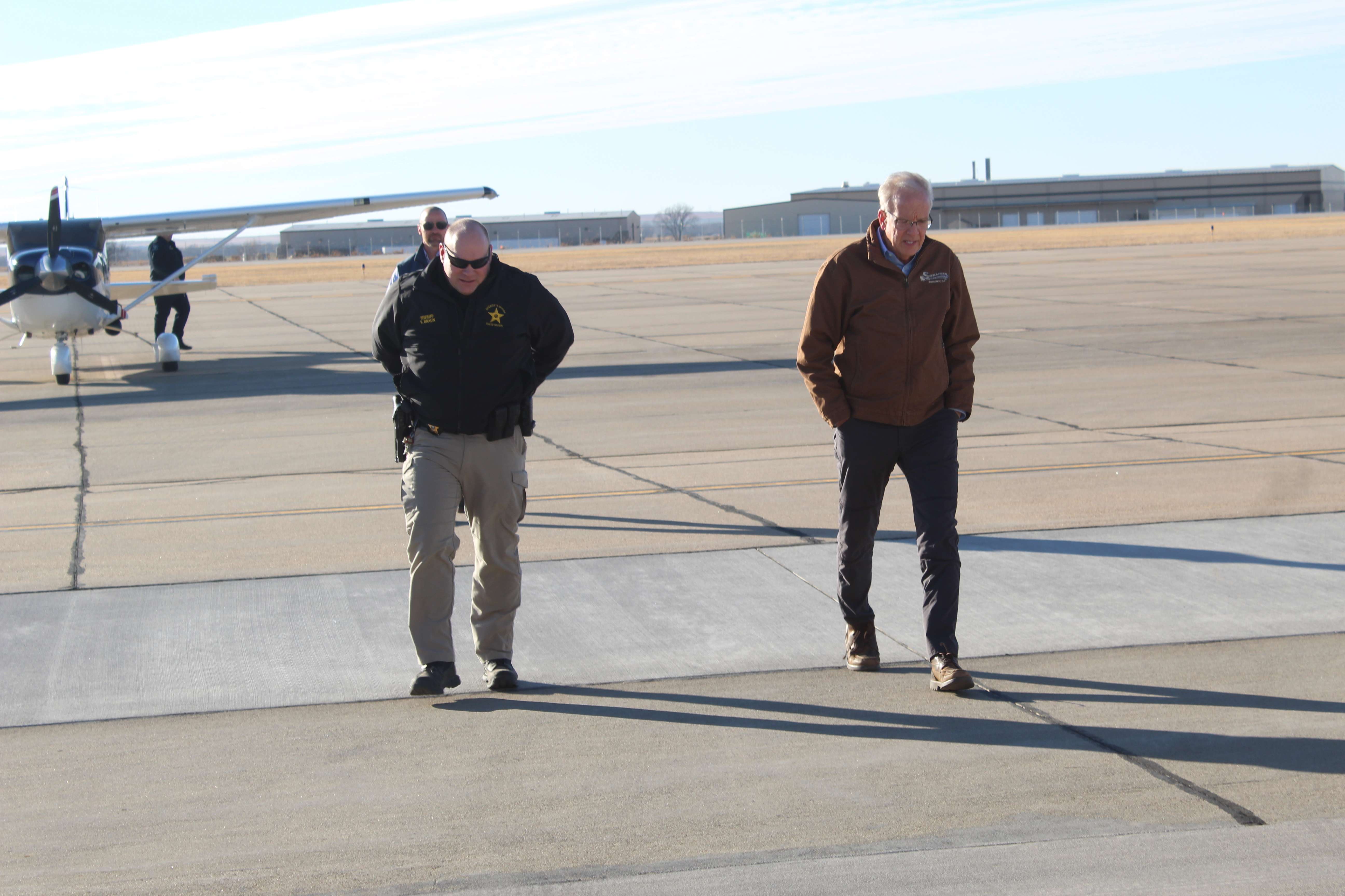 Ellis County Sheriff Scott Braun and U.S. Sen. Jerry Moran, R-Kan., disembark from a Kansas Highway Patrol airplane after surveying fire damage from the air Friday.<br>