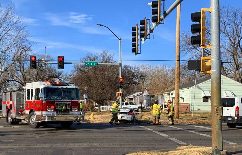 <b>Firefighters sweep up glass and other vehicle debris from the street behind a Pontiac Grand Am involved in a two-vehicle collision Tuesday morning.</b> Salina Post photo