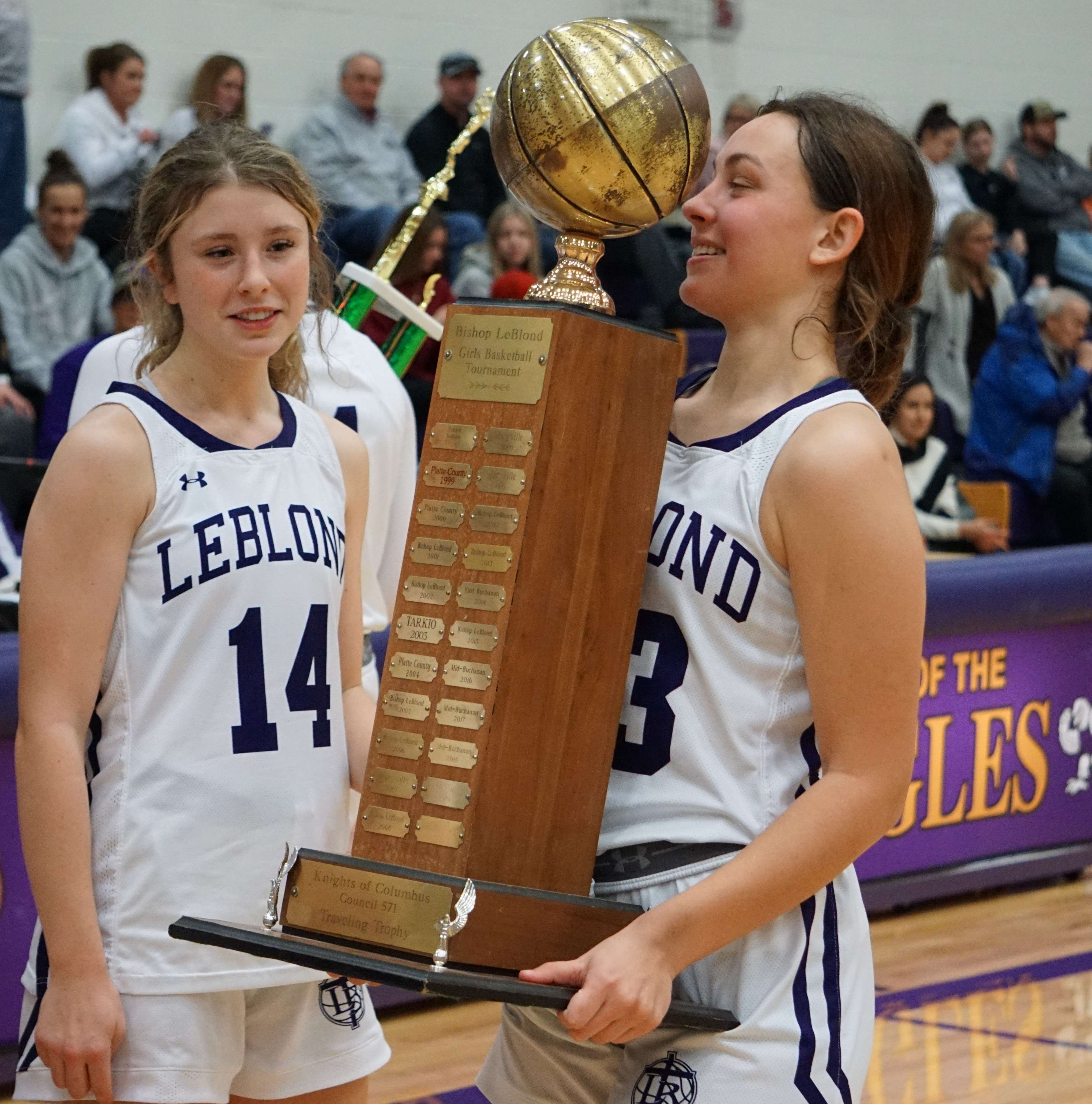 Tatum Studer (left) and Sloan Lewis (right) hold the traveling LeBlond tournament trophy following the Eagles' win over Plattsburg Wednesday. Photo by Tommy Rezac.