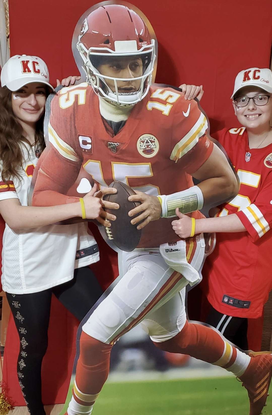 Hays teen Sophia Linenberger, right, and her sister, Holly Linenberger, pose with a cutout of Patrick Mahomes depicting the Chiefs' quarterback wearing Sophia's "Sophia Strong" wristband.