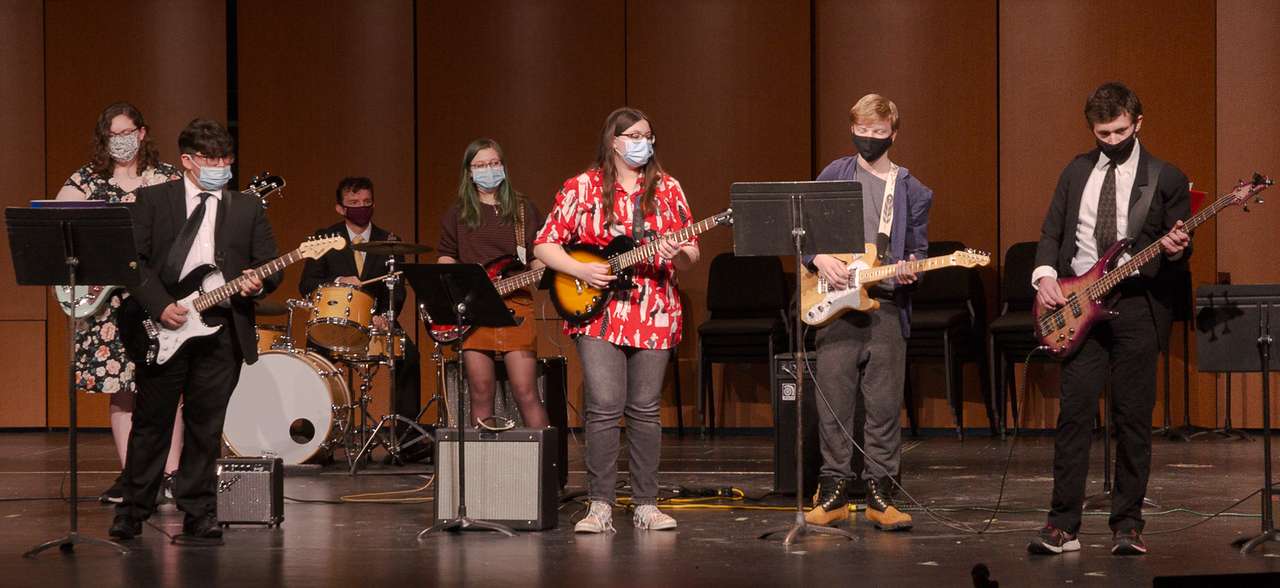 Members of the guitar ensemble, directed by Dr. Mckay Tebbs, associate professor of music, background on drums, perform during the final concert of the 49th annual High Plains Band and Choir Festival Feb. 2, 2021, in Chadron State's Memorial Hall Auditorium.(Photo by Abigail Swanson/Chadron State College)