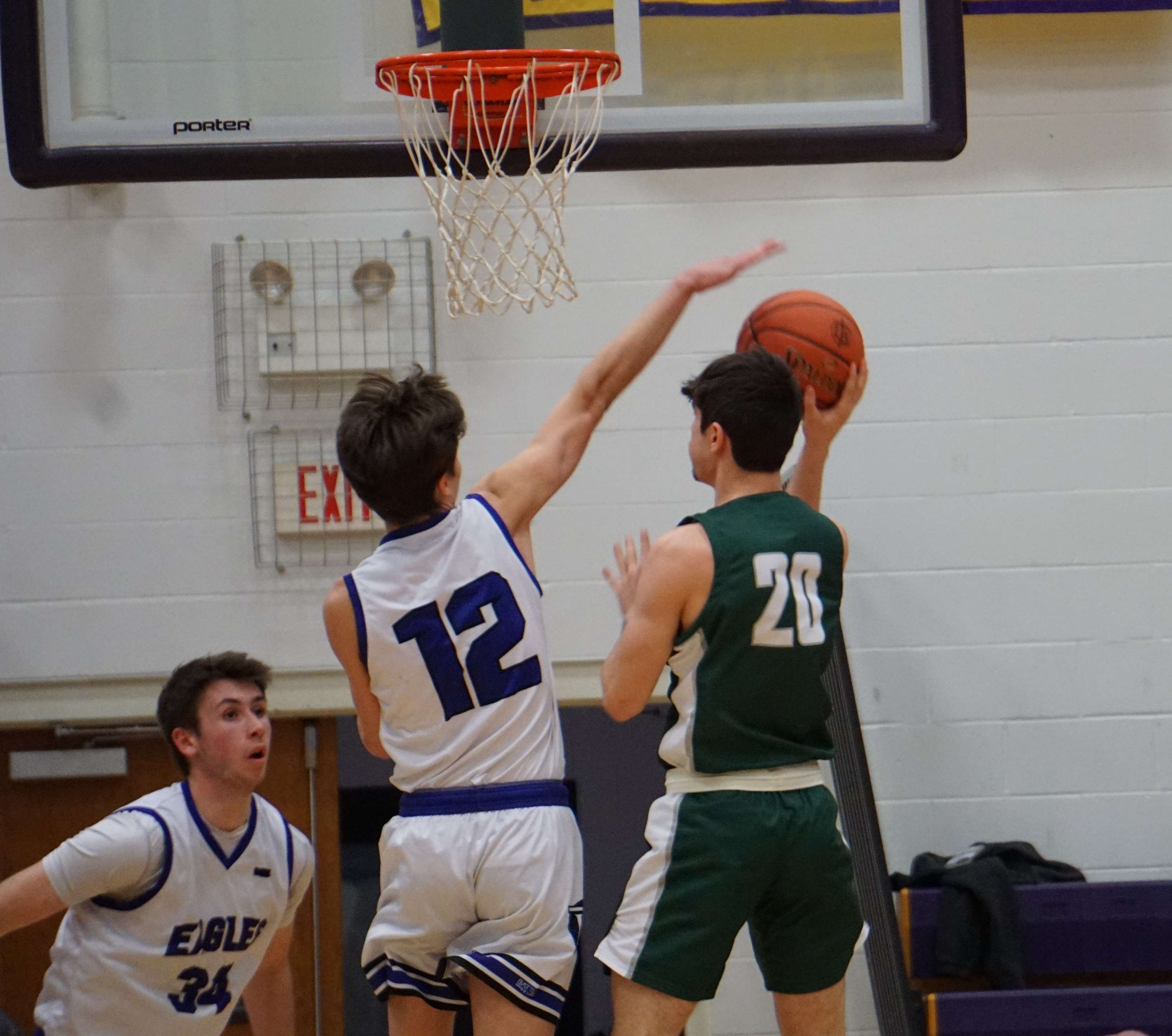 Bishop LeBlond's Noah Eidmann (12) throws a block against Lafayette's Mikey Thomas (20) as the Irish topped the Eagles 61-55 Friday night. Photo by Tommy Rezac.