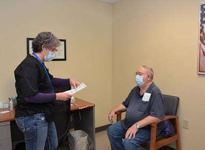 <b>Debbie Allton, lead RN at the Salina VA clinic, screens Lawayne Cart to determine if his observation time after receiving the COVID-19 vaccine will be 15 or 30 minutes.</b>