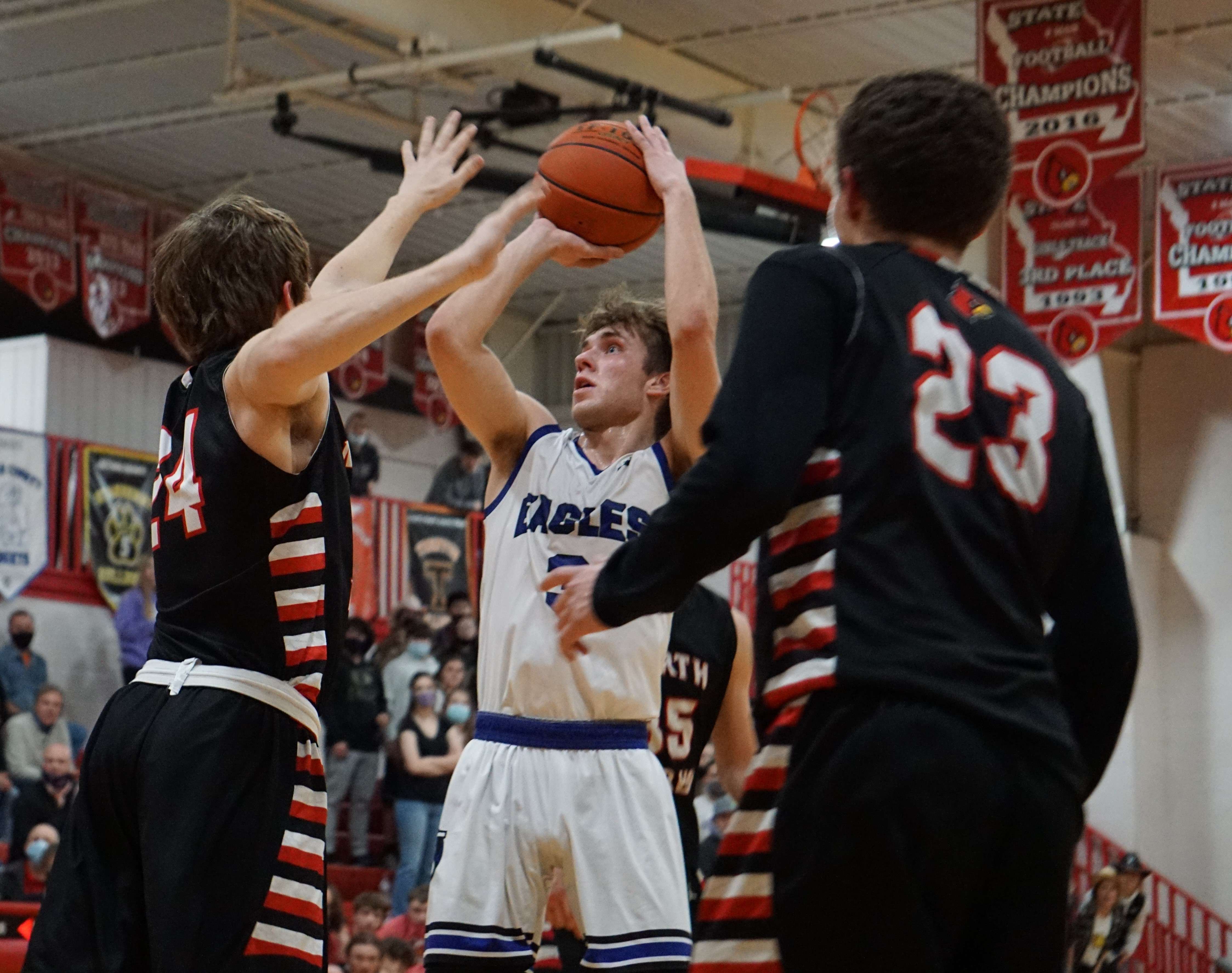 LeBlond's Chris Guldan (middle) takes a jump shot against North Andrew's Hayden Ecker (24) in the second half of Thursday's Class 2 District 16 semifinal at North Andrew High School. Photo by Tommy Rezac.