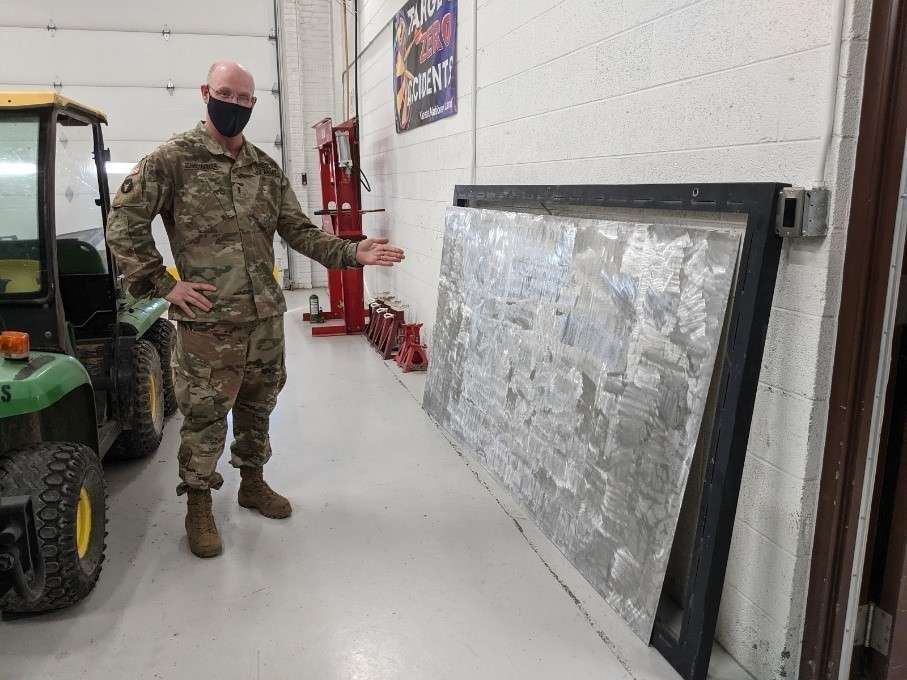 Chief Warrant Officer 3 Michael Schmidtberger, Field Maintenance Shop 1 shop foreman, shows off a work in progress for their outdoor shop sign Jan. 28, 2021. Part of their new sign is being finished in Salina as the former one became sun-bleached and faded over the years. The FMS 1 took first place at the National Guard Bureau for the annual Army Award for Maintenance Excellence in December 2020 in the Tables of Distribution and Allowances category. (Photo by Staff Sgt. Jennifer Milnes)